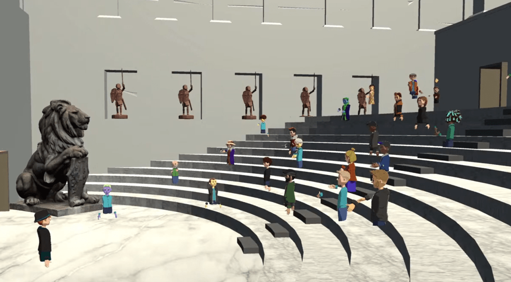 A virtual gathering in an amphitheater with diverse animated characters, featuring a prominent lion sculpture and historical statues in the background.